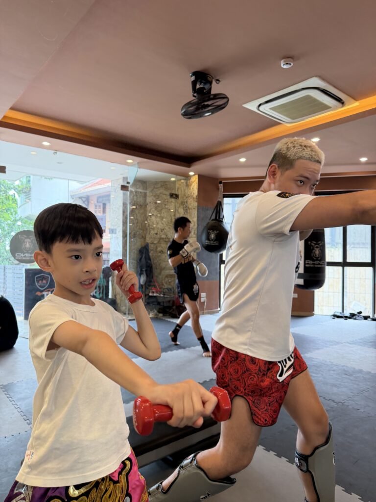 Coach correcting a young student's stance during kids muay thai classes