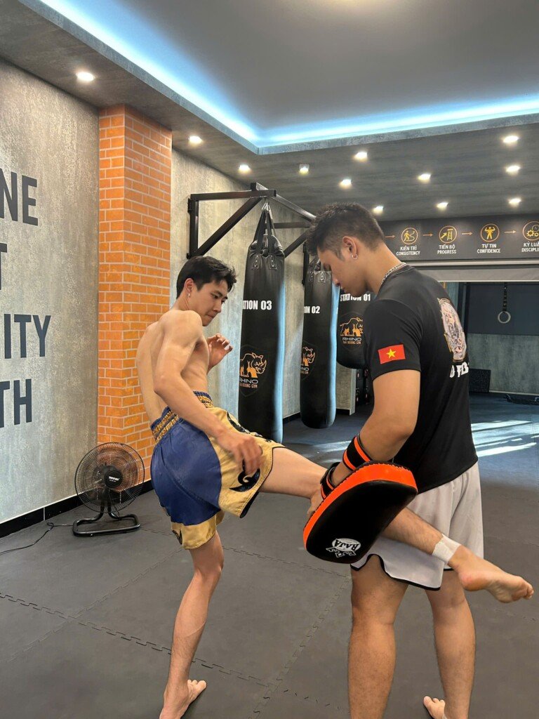  Khoảnh khắc ống chân học viên tiếp xúc với đích đá trong bài tập low kick tại RHINO